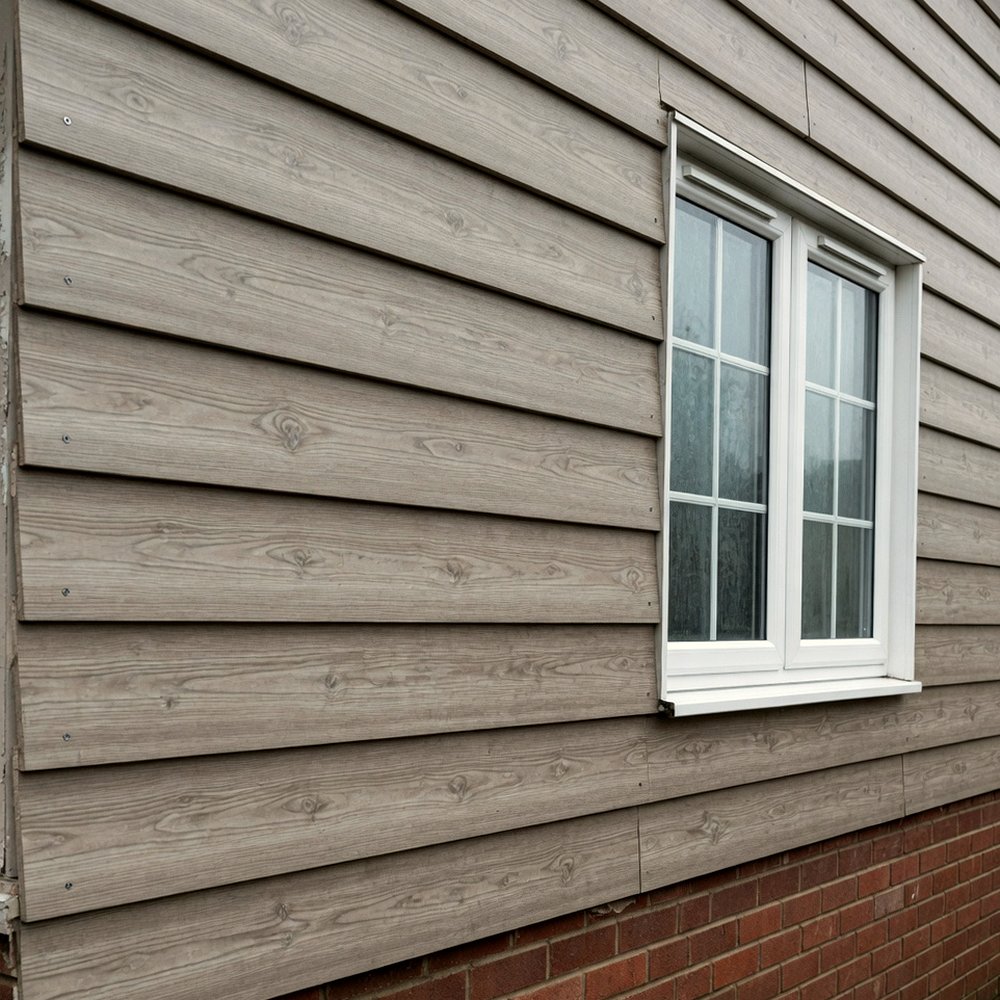 Timber-effect composite cladding boards on a house wall
